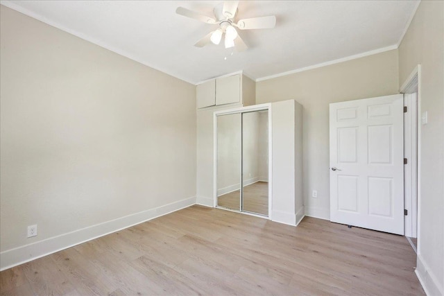 unfurnished bedroom featuring light wood finished floors, baseboards, ornamental molding, and a closet