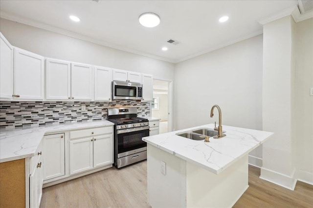 kitchen with stainless steel appliances, backsplash, a sink, light wood-type flooring, and crown molding