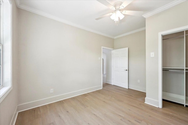 unfurnished bedroom featuring crown molding, light wood finished floors, a closet, and baseboards