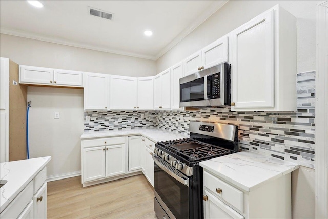 kitchen with tasteful backsplash, light stone counters, appliances with stainless steel finishes, visible vents, and crown molding