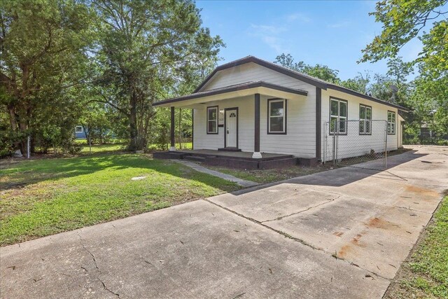 view of front facade featuring driveway, a front yard, and a porch