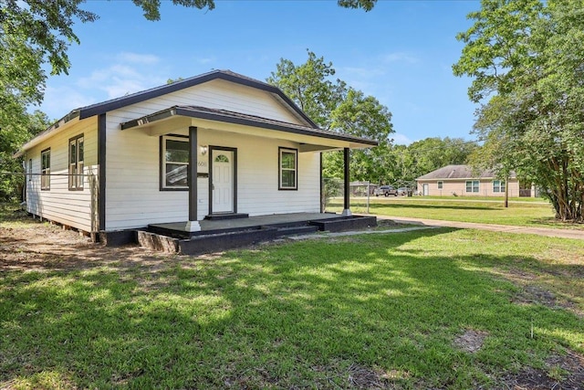 bungalow-style home with covered porch and a front lawn