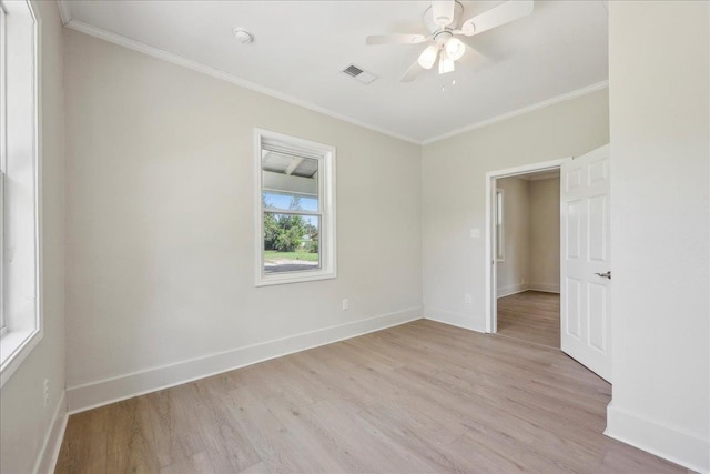 spare room featuring baseboards, ornamental molding, ceiling fan, and light wood finished floors