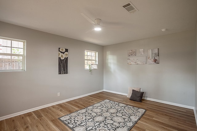 empty room featuring hardwood / wood-style flooring, ceiling fan, and a wealth of natural light