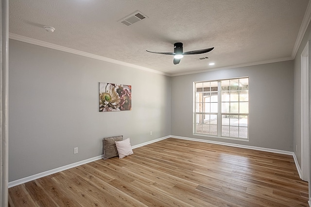 empty room with a textured ceiling, light hardwood / wood-style floors, and ornamental molding