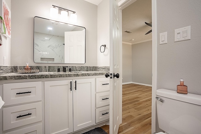 bathroom featuring hardwood / wood-style floors, vanity, toilet, and ornamental molding