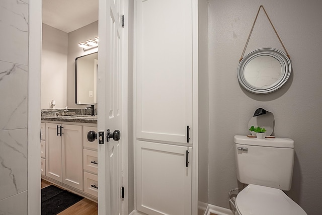 bathroom featuring hardwood / wood-style floors, vanity, and toilet