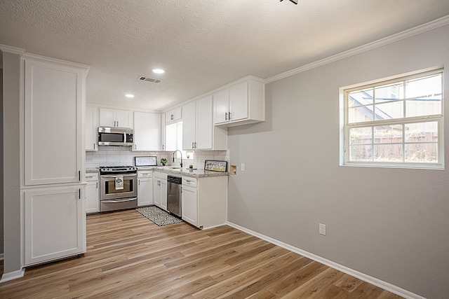 kitchen featuring white cabinets, decorative backsplash, and appliances with stainless steel finishes