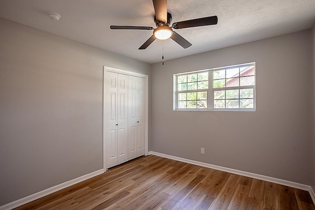 unfurnished bedroom with ceiling fan, light hardwood / wood-style flooring, and a closet