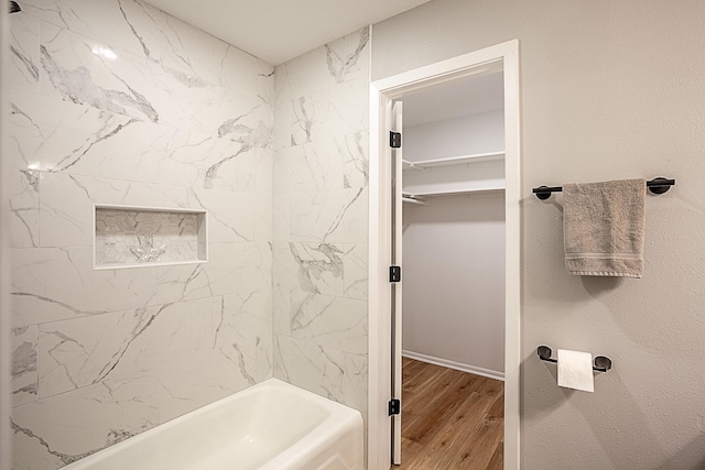 bathroom with hardwood / wood-style flooring and tiled shower / bath combo