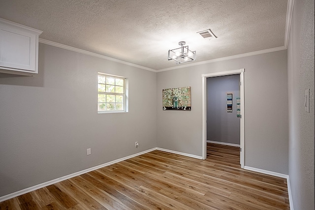 unfurnished dining area with a chandelier, a textured ceiling, light hardwood / wood-style flooring, and ornamental molding