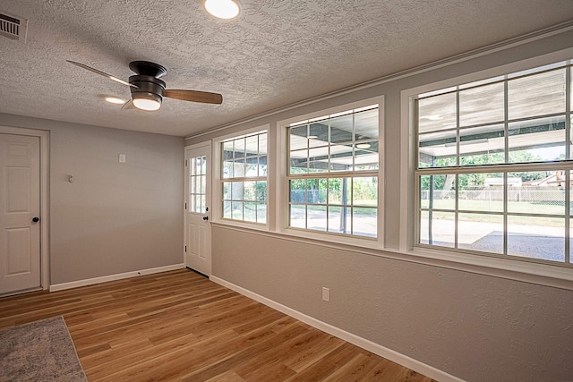 spare room with hardwood / wood-style floors, a textured ceiling, and ceiling fan