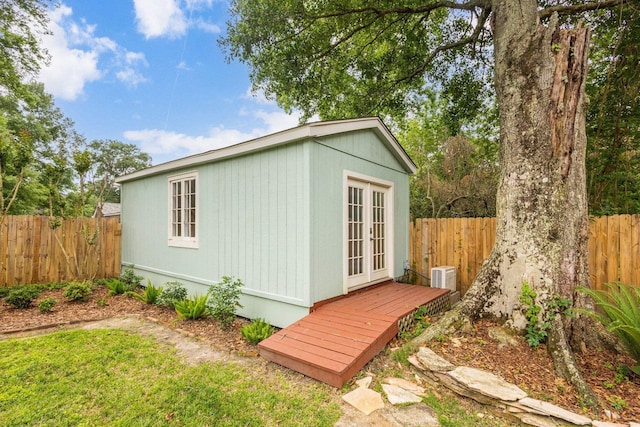 view of outbuilding featuring central air condition unit, french doors, and a fenced backyard