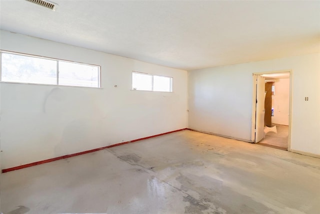 spare room featuring concrete floors and visible vents