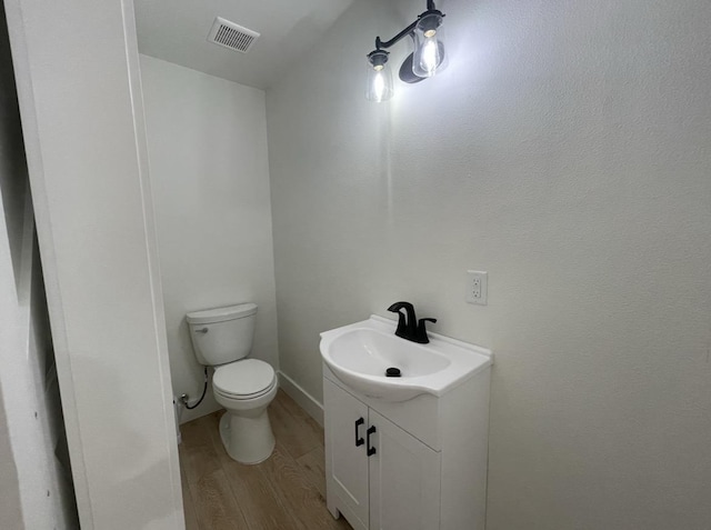 bathroom featuring hardwood / wood-style floors, vanity, and toilet