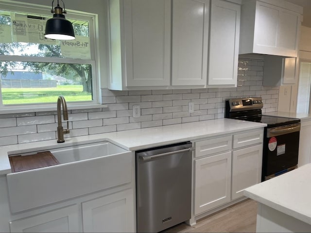 kitchen featuring backsplash, custom range hood, stainless steel appliances, decorative light fixtures, and white cabinetry