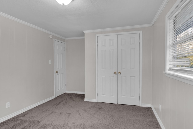 unfurnished bedroom featuring a textured ceiling, crown molding, light carpet, and a closet