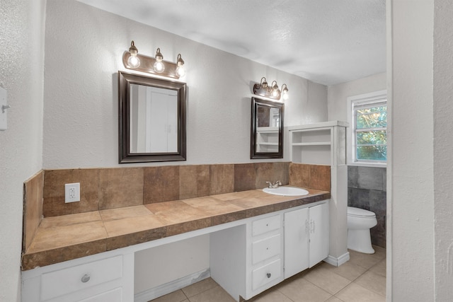 bathroom with tile patterned flooring, vanity, and toilet