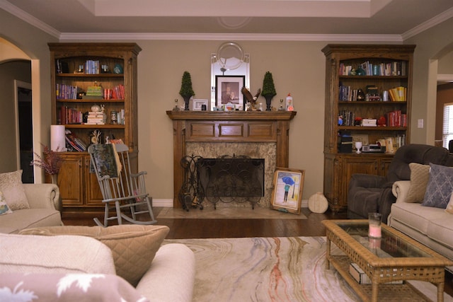 living room with arched walkways, a fireplace, and crown molding