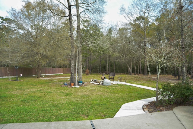 view of yard featuring an outdoor fire pit and fence