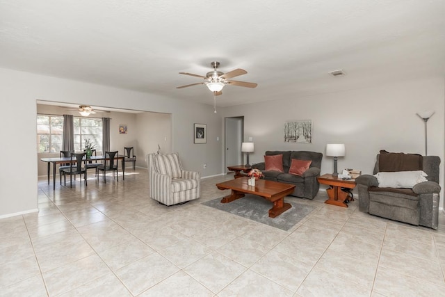 living room with light tile patterned floors, baseboards, visible vents, and a ceiling fan
