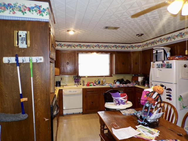 3100 Boyd Ave, Groves, TX 77619 - kitchen featuring white appliances, light countertops, light wood finished floors, and an ornate ceiling
