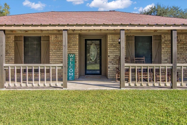 property entrance featuring covered porch and a yard