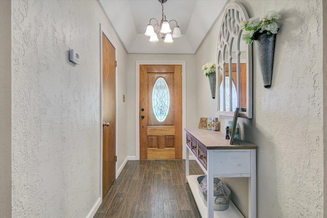 foyer entrance featuring vaulted ceiling and a chandelier