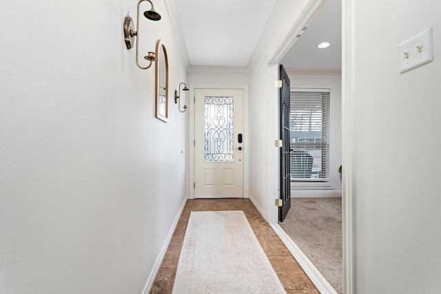 doorway featuring crown molding and carpet floors