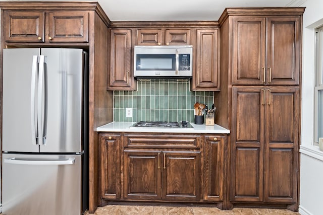 kitchen with appliances with stainless steel finishes and backsplash