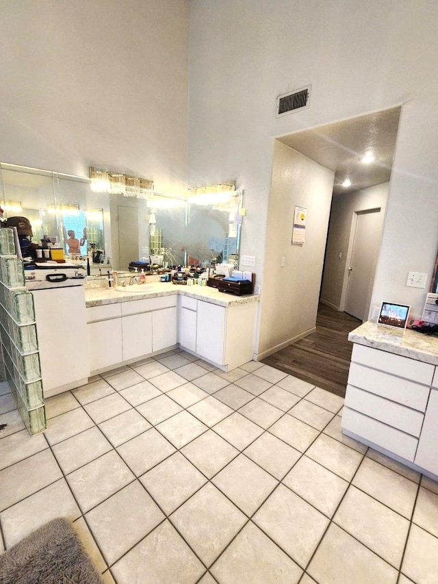 interior space featuring a high ceiling, vanity, and tile patterned floors