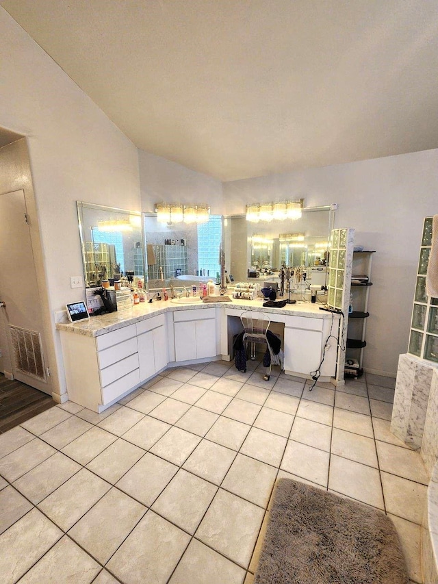 bathroom featuring tile patterned floors, vanity, and vaulted ceiling