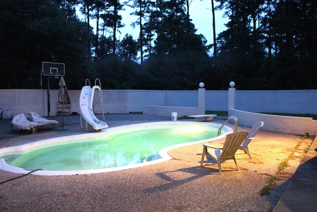 view of swimming pool with a patio and a water slide