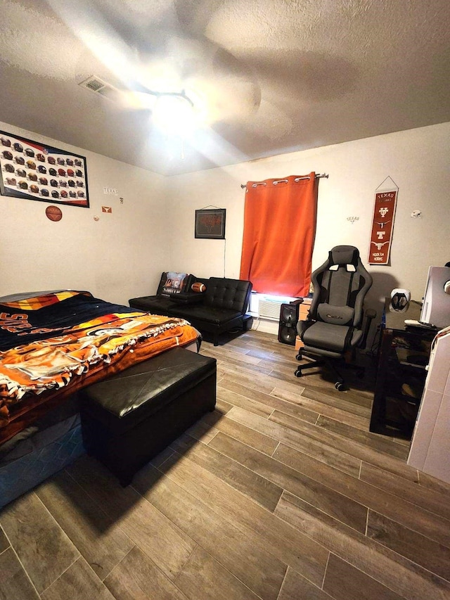 bedroom with wood-type flooring and a textured ceiling