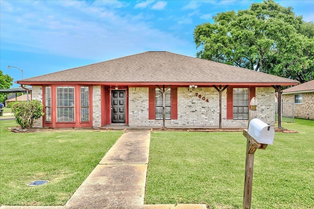 7804 Spring Meadow Ln, Port Arthur, TX 77642 - view of front of home featuring a shingled roof and a front lawn