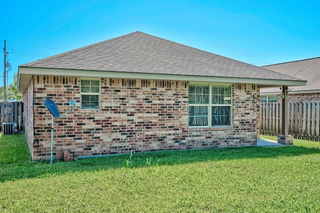 6640 Palace Dr, Lumberton, TX 77657 - view of property exterior featuring a lawn, fence, brick siding, a shingled roof, and central AC unit