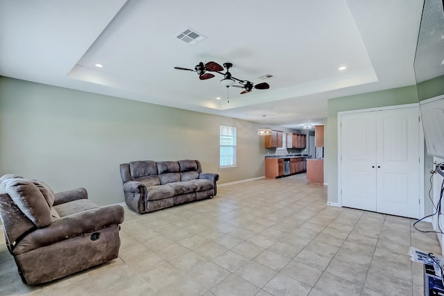 6640 Palace Dr, Lumberton, TX 77657 - living room with light tile patterned floors, visible vents, a tray ceiling, and a ceiling fan