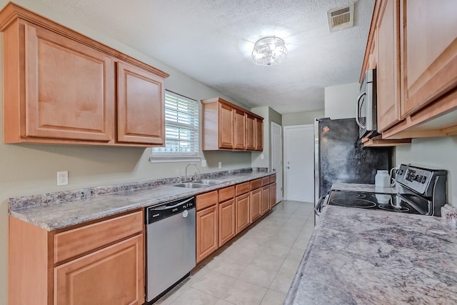 6640 Palace Dr, Lumberton, TX 77657 - kitchen with a textured ceiling, visible vents, light countertops, a sink, and stainless steel appliances