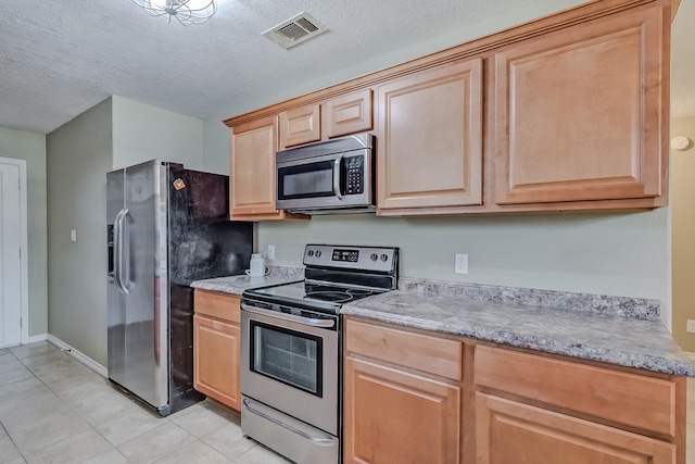 6640 Palace Dr, Lumberton, TX 77657 - kitchen featuring light tile patterned floors, light brown cabinetry, visible vents, and stainless steel appliances
