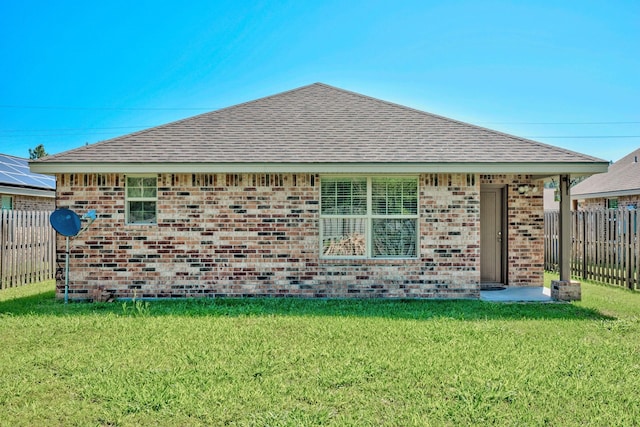 6640 Palace Dr, Lumberton, TX 77657 - rear view of house featuring brick siding, fence, a shingled roof, and a lawn