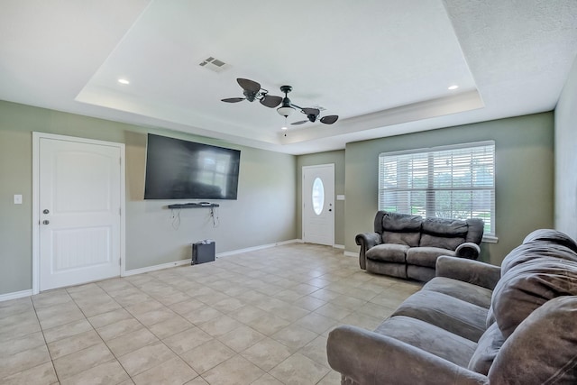 6640 Palace Dr, Lumberton, TX 77657 - living room with light tile patterned floors, visible vents, a tray ceiling, and baseboards