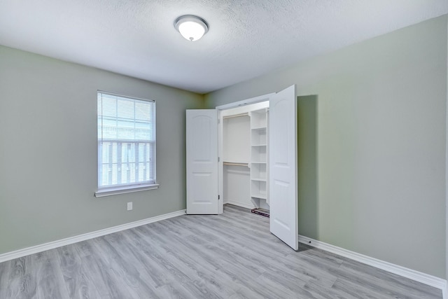 6640 Palace Dr, Lumberton, TX 77657 - unfurnished bedroom with light wood-style flooring, baseboards, and a textured ceiling