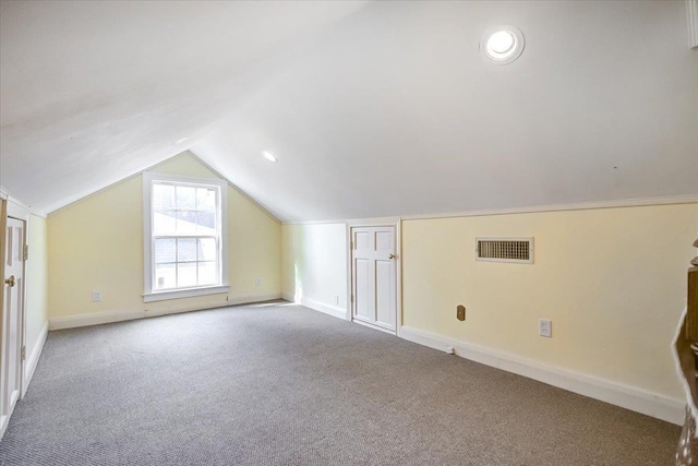 additional living space featuring lofted ceiling and light carpet