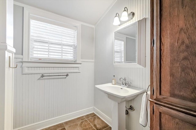 bathroom featuring tile patterned flooring, wooden walls, and crown molding