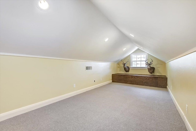 bonus room with light colored carpet and vaulted ceiling