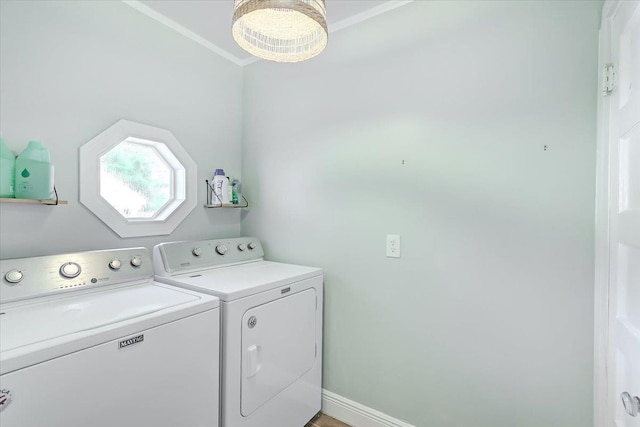 laundry area with ornamental molding and washing machine and clothes dryer