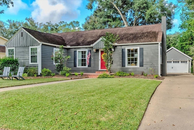 ranch-style home with a garage, an outbuilding, and a front yard