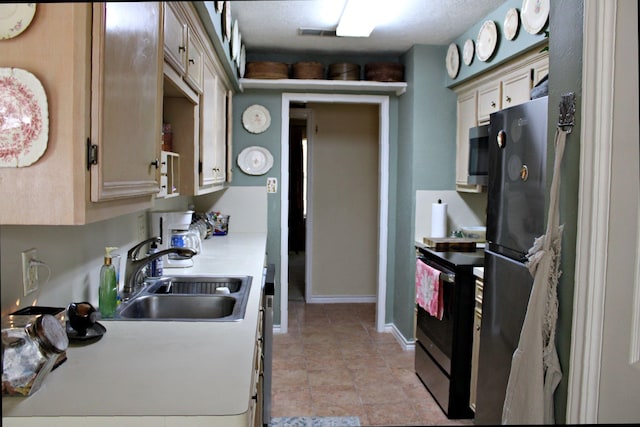 kitchen with cream cabinetry, stainless steel appliances, and sink