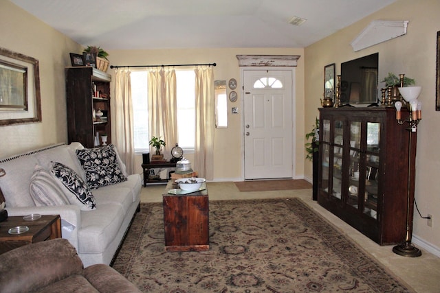 carpeted living room with lofted ceiling