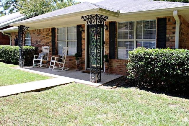 property entrance with a porch and a lawn